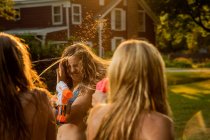 Chicas teniendo pelea de agua con pistolas de agua - foto de stock