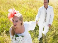 Coppia sposata che cammina in un campo — Foto stock
