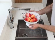 Mann wäscht Äpfel — Stockfoto