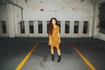 Portrait of young woman looking sideways standing in indoor parking lot — Stock Photo