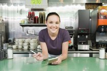 Smiling waitress in a diner — Stock Photo