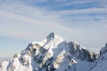 Заснеженная вершина горы при ярком солнечном свете — стоковое фото