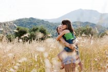 Mädchen trägt Freund im Feld — Stockfoto