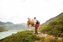 Femme caressant une vache, Alpes, Tyrol, Autriche — Photo de stock