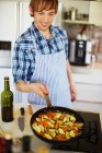Hombre freír verduras en la cocina - foto de stock