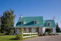 Villa mit türkisfarbenem Dach und grünem Garten in der Nähe — Stockfoto