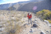Mulher mochileiro caminha até Cottonwood Canyon, Death Valley National Park, Califórnia novembro 2012. — Fotografia de Stock