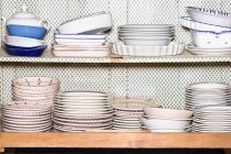Plates and bowls on shelves — Stock Photo