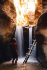 Caminhante em caverna de arenito por cachoeira, Kanarraville, Utah, EUA — Fotografia de Stock