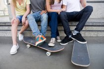 Обрезанное изображение подростков со скейтбордами в скейт-парке — стоковое фото