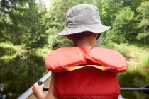 Young boy in canoe, rear view — Stock Photo