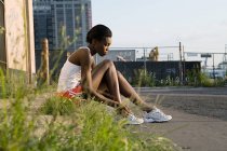 Runner sitting on sidewalk outdoors — Stock Photo