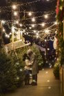 Romantique couple heureux profiter de la ville pendant les vacances d'hiver embrasser par des arbres de Noël — Photo de stock