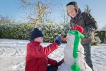 Jungen basteln Schneemann im Garten — Stockfoto