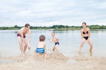 Família jogando em uma praia — Fotografia de Stock