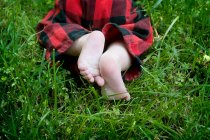 Plan recadré de bébé rampant sur l'herbe verte — Photo de stock