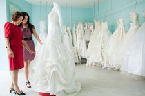 Mother and daughter looking at wedding dresses — Stock Photo