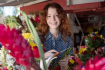 Retrato de floristería sonriente trabajando en la tienda - foto de stock