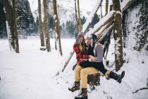 Woman sitting on man in snow-covered landscape — Stock Photo