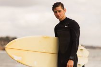 Portrait of young man, holding surfboard — Stock Photo