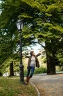 Woman playing on streetlight in park — Stock Photo
