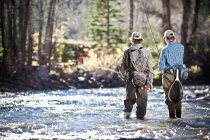 Fishermen ankle deep in river fly fishing, Colorado, USA — Stock Photo