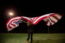 Fille tenant drapeau américain la nuit — Photo de stock
