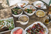 Comida mediterránea servida en la mesa de jardín - foto de stock