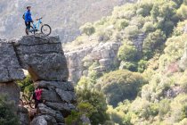 Mountain biking couple on rock formation looking ahead — Stock Photo