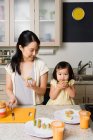 Eine Tochter hilft ihrer Mutter in der Küche — Stockfoto