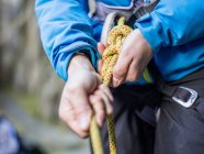 Alpinista mãos amarrando corda — Fotografia de Stock
