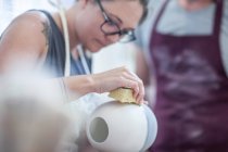 Kapstadt, Südafrika, junge Frau putzt sorgfältig Schale in Keramik-Werkstatt — Stockfoto