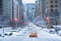 Gelber Taxiwagen auf verschneiter Stadtstraße — Stockfoto
