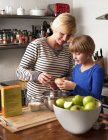 Mother and daughter in kitchen preparing food — Stock Photo