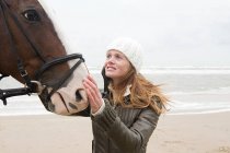 Femme et cheval à la plage — Photo de stock
