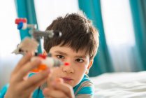 Boy playing with toy in bedroom — Stock Photo