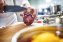 Koch bereitet sich darauf vor, rote Zwiebeln in Scheiben zu schneiden, Nahaufnahme — Stockfoto