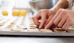 Обрезанный образ пекаря, формирующего тесто на кухне — стоковое фото