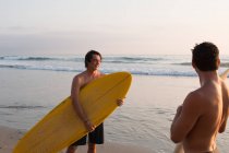 Two young men on beach, holding surfboards — Stock Photo