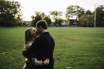 Young couple outdoors, embracing, kissing — Stock Photo