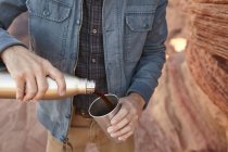 Man pouring hot drink from drinking flask, Page, Arizona, USA — Stock Photo