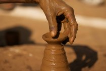 Potter hand at work with wet clay — Stock Photo