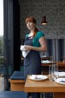 Mitte erwachsene Frau poliert Glas in Restaurant — Stockfoto