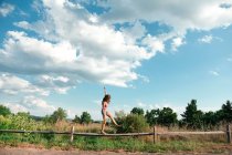 Девочка-подросток балансирует на деревянном заборе — стоковое фото