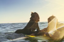 Surfing couple leaning on surfboards in sea, Newport Beach, California, USA — Stock Photo