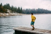 Молодой человек, идущий по пирсу на озере Шавер, Калифорния, США — стоковое фото