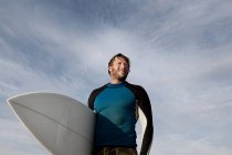 Surfista transportando prancha ao ar livre — Fotografia de Stock