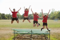 Girl soccer players jumping off bleachers — Stock Photo
