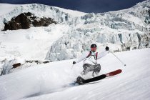 Esquiador masculino acelerando descida — Fotografia de Stock