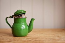 Close-up view of money in green teapot indoors — Stock Photo
